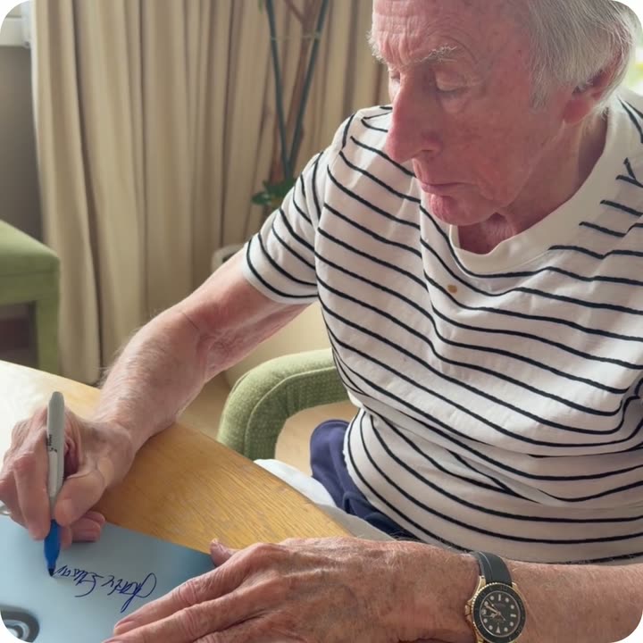 Sir Jackie Stewart signing a Framebook print